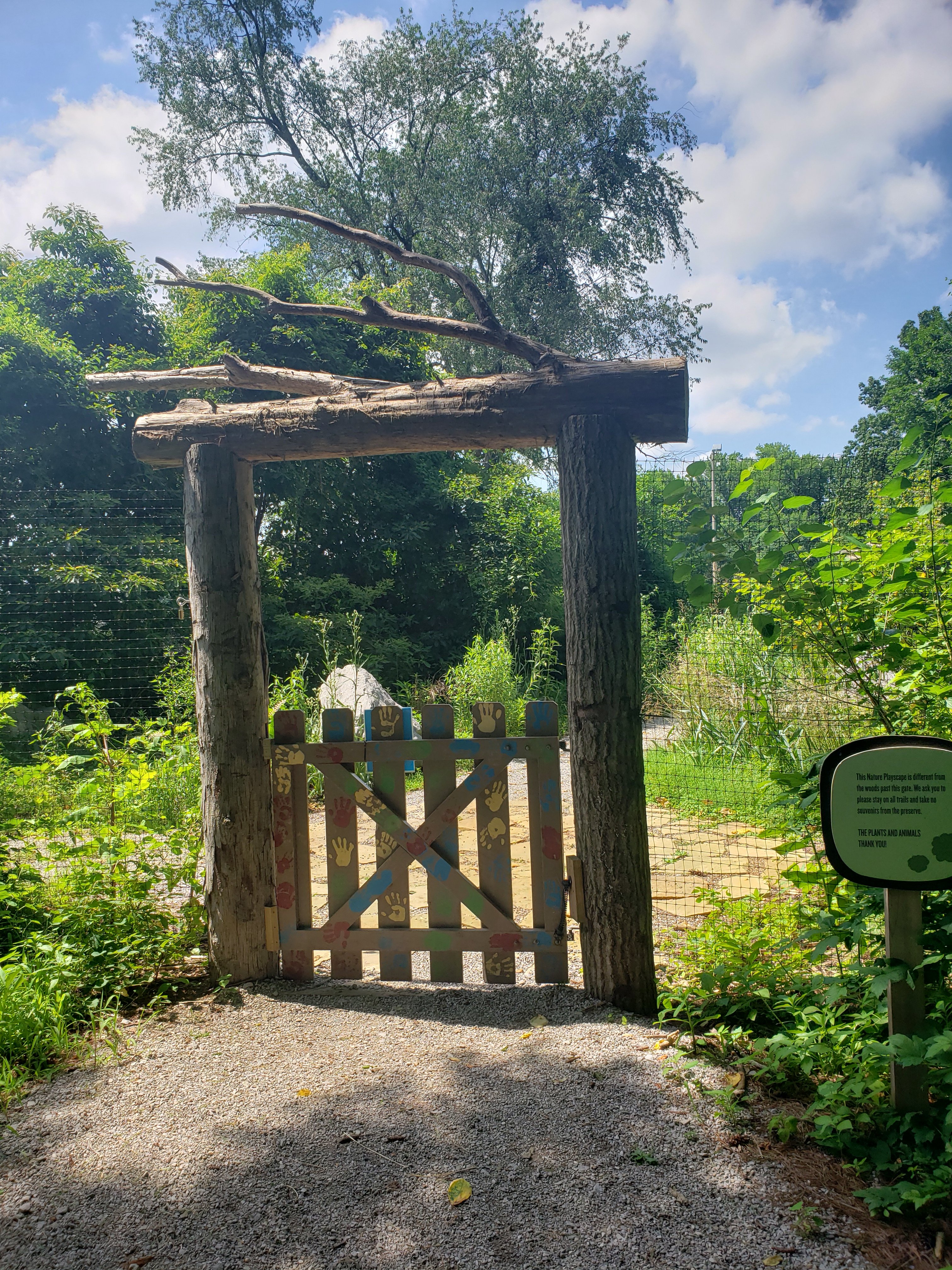 Photo of gate at Wesselman Woods in Evansville, Indiana. Gate is in an arch made of logs.  Things to do with kids in Evansville Indiana. Kids activities in Evansville 