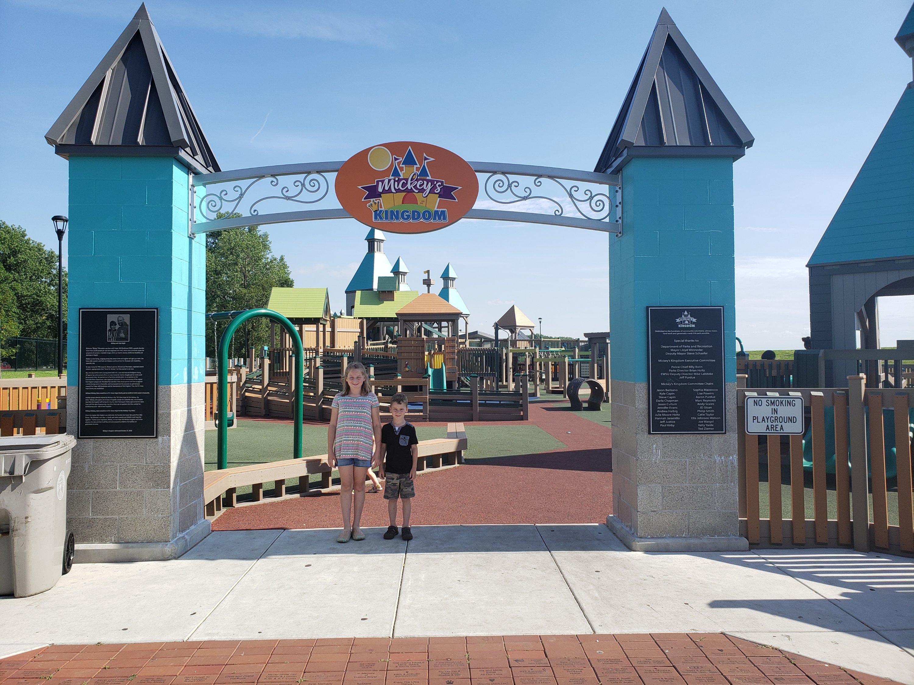 A young girl and a boy child standing under the main arch sign at Mickey's Kingdom Park for kids in Evansville, Indiana  Things to do with kids in Evansville Indiana. Kids activities in Evansville 