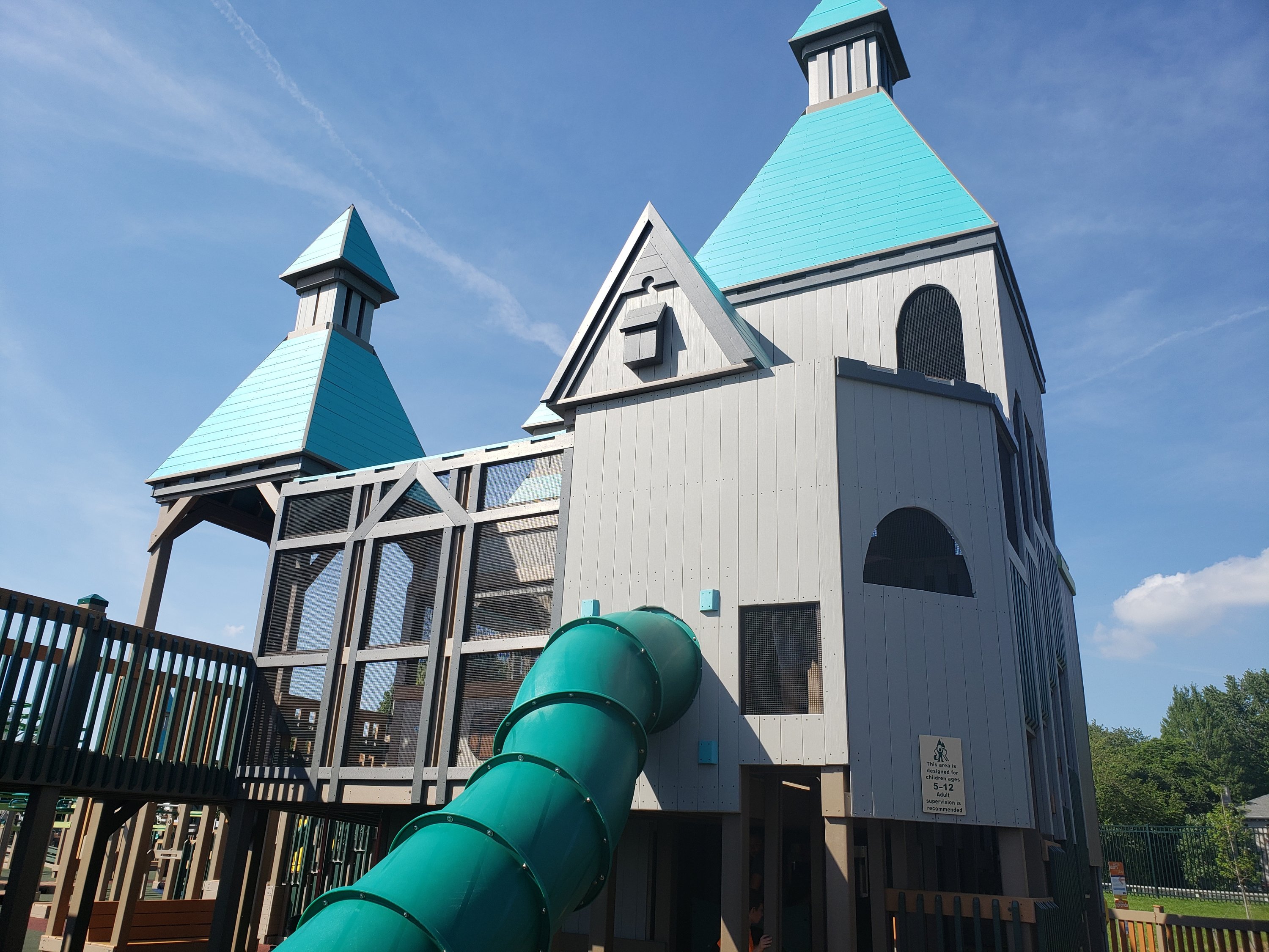 Large green tube slide coming out of playhouse at Mickey's Kingdom Park for kids in Evansville, Indiana 