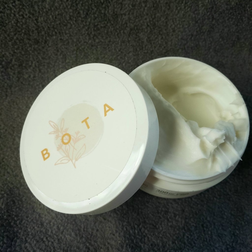 BOTA Muscle Melt Creme, cover open on dark surface