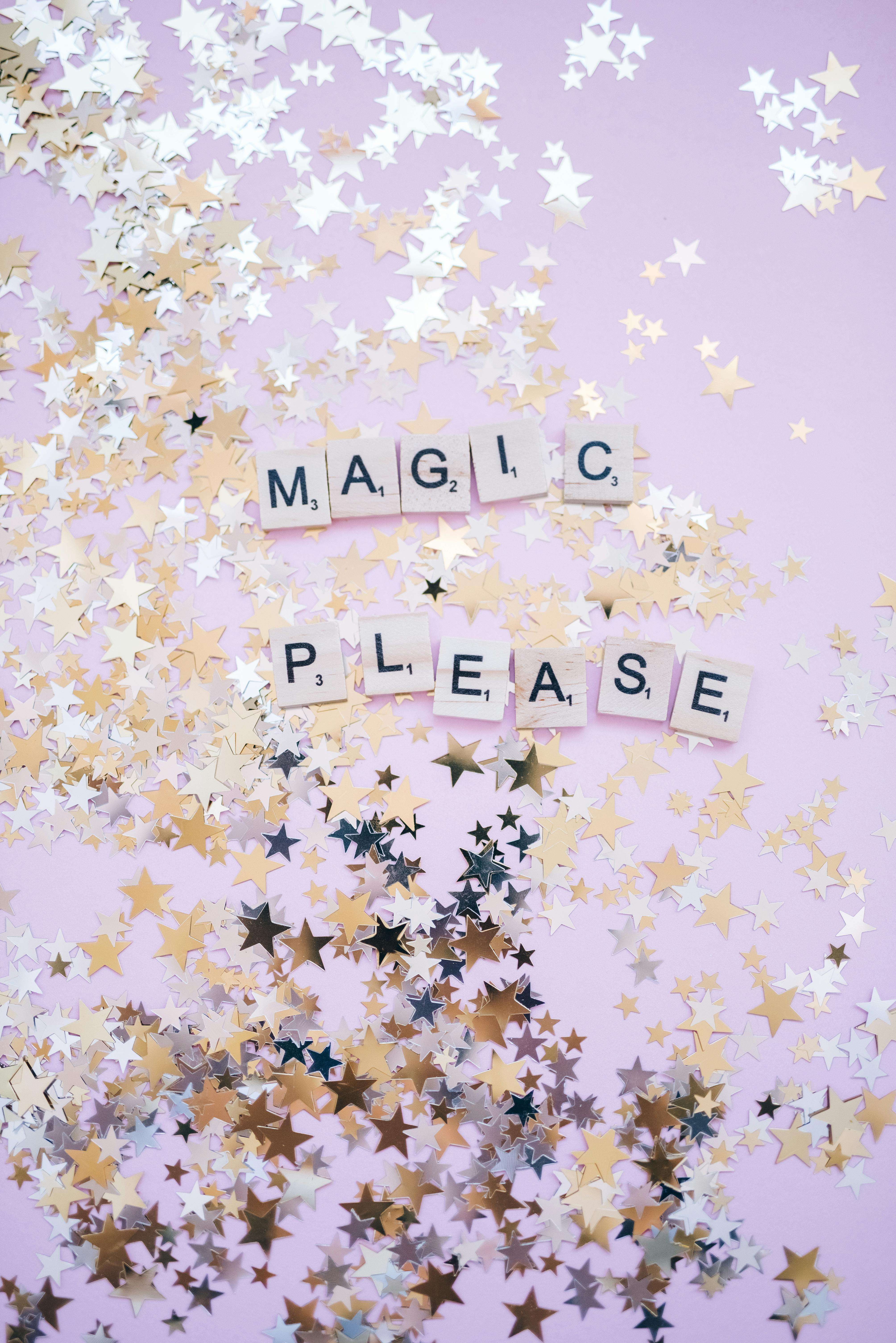 gold foil confetti stars on a pink background with scrabble tiles spelling out MAGIC PLEASE 