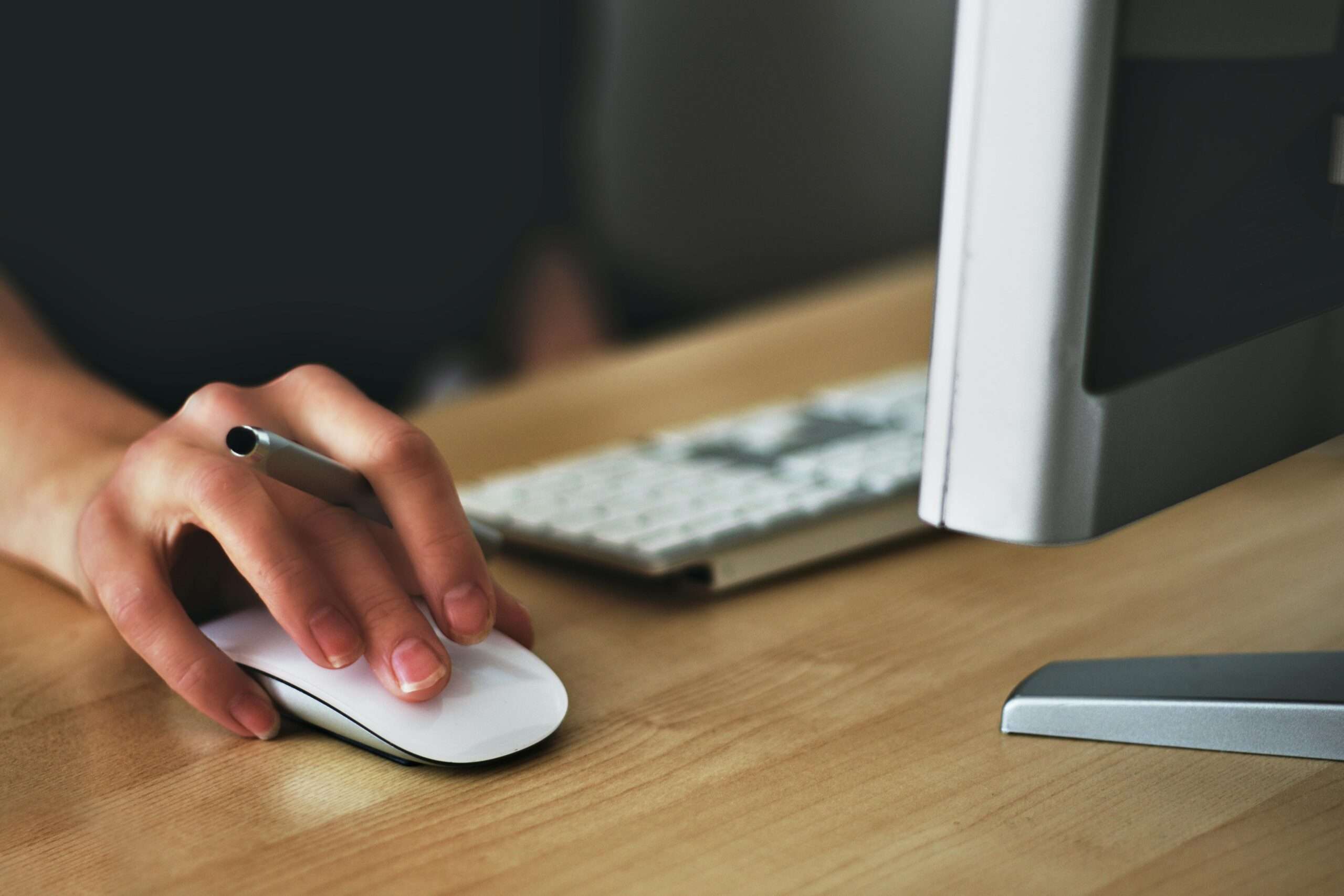 Wireless keyboard and mouse with a hand on the mouse working as an idea for work from home gifts
