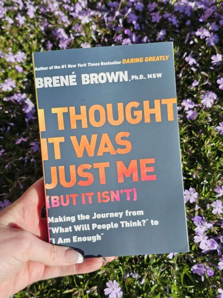 I Thought It Was Just Me book in front of purple flowers